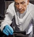 Optics engineer John Hagopian works with a nanotube material sample in this file photograph from NASA's Goddard Space Flight Center in Greenbelt, Md.