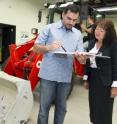 Purdue University professor Monika Ivantysynova and doctoral student Naseem Daher discuss research related to a new hydraulic-steering technology, while graduate student Michael Sprengel looks over the electronic controls of a front loader. Researchers led by Ivantysynova, the Maha Fluid Power Systems Professor, have shown how to reduce fuel consumption while dramatically improving the efficiency of hydraulic steering systems in heavy construction equipment.