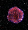 This is a photograph of the Tycho supernova remnant taken by the Chandra X-ray Observatory. Low-energy X-rays (red) in the image show expanding debris from the supernova explosion and high energy X-rays (blue) show the blast wave, a shell of extremely energetic electrons.