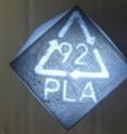 Light shines through the bottom of a 3-D printed pencil holder, revealing its polymer resin code for recycling.