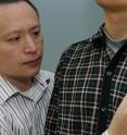 Gang Luo, Ph.D., Associate Scientist at Mass. Eye and Ear/Schepens, and Assistant Professor of Ophthalmology at Harvard Medical School, adjusts the wearable device that his team created to help those who are visually impaired avoid collision while walking.