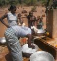 This image shows women collecting water at a well in rural Burkina Faso, West Africa.